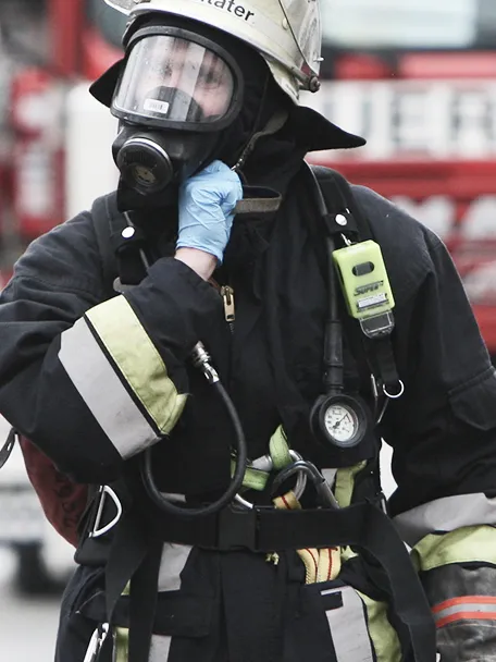 Feuerwehrmann in Schutzkleidung und Atemmaske.