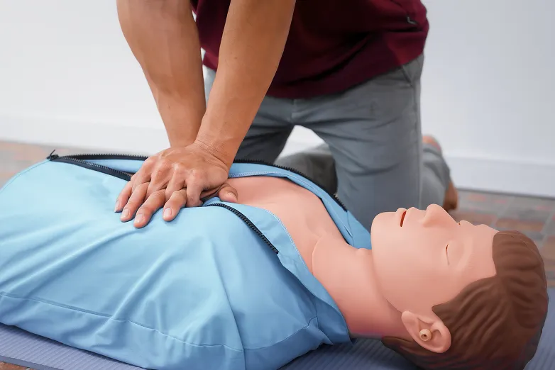 Eine Person führt Herzdruckmassage an einer Übungspuppe durch.