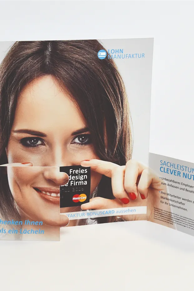 Auf einem gefalteten Werbeflyer hält eine Frau eine Kreditkarte vor ihrem Gesicht.